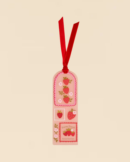 Decorative tag with strawberry design and red ribbon on a beige background