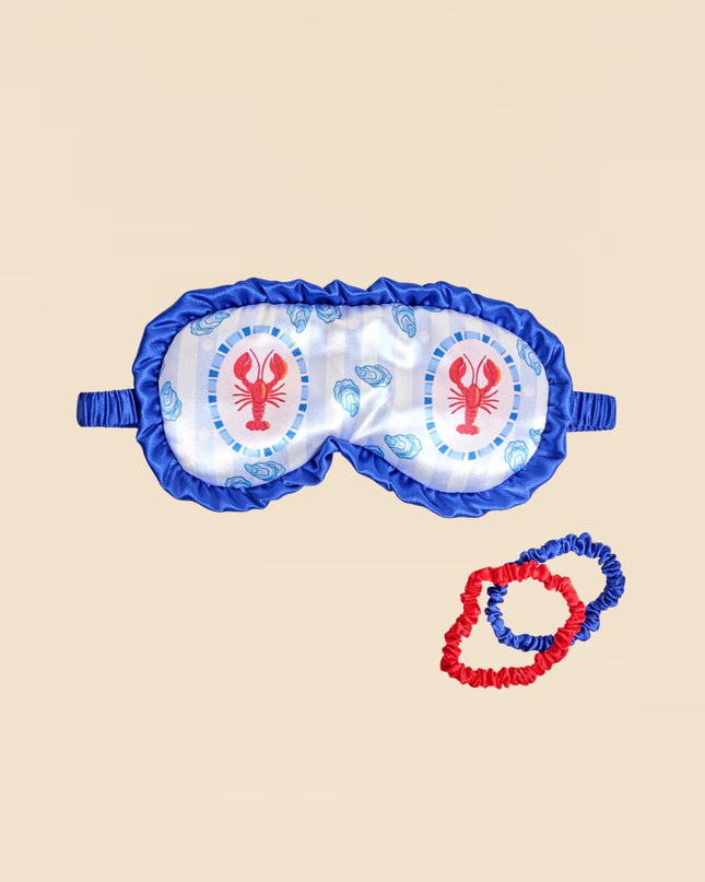 Sleep mask with lobster design on a beige background