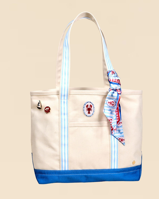 Beige tote bag with blue accents and a decorative ribbon on a beige background