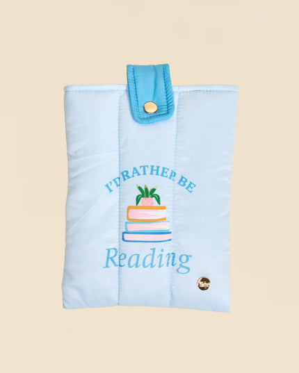 Light blue reading glasses case with 'I'd rather be reading' text and cake illustration on a beige background