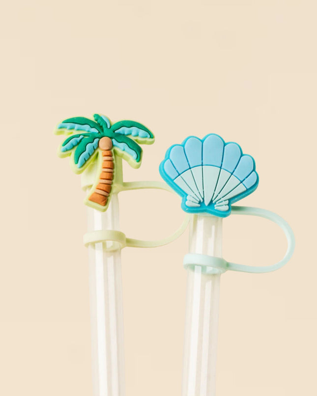 Two straws with tropical-themed ends on a beige background