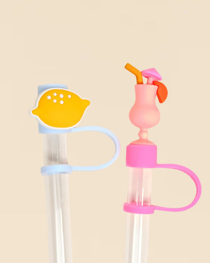 Two colorful straws with decorative ends on a beige background