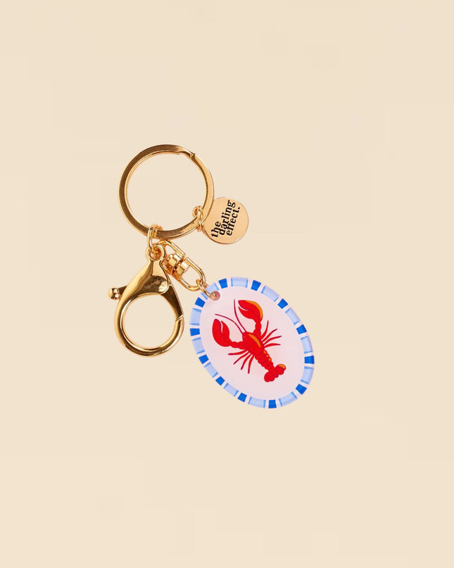 Keychain with lobster charm on a beige background