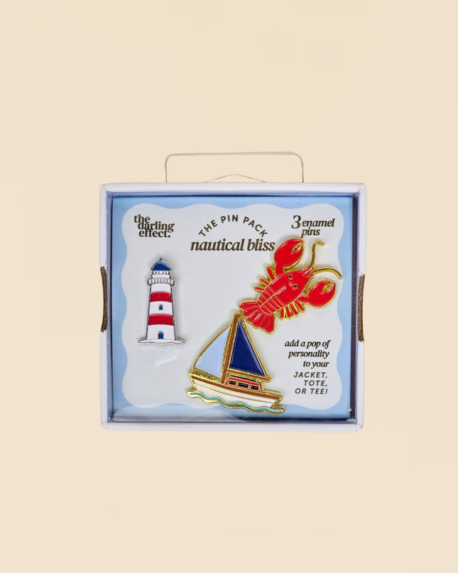Box of nautical-themed pins with a lighthouse, sailboat, and lobster design on a beige background.