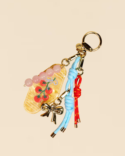 Decorative keychain with various charms on a beige background
