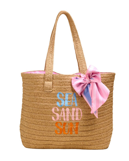 Woven tote bag with 'SEA SAND SUN' text and pink bow on a white background