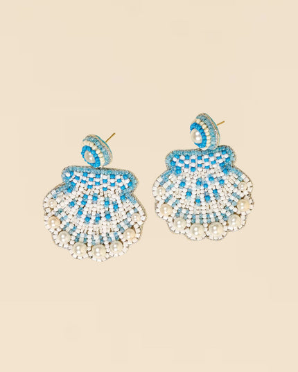 Pair of blue and white beaded earrings on a beige background