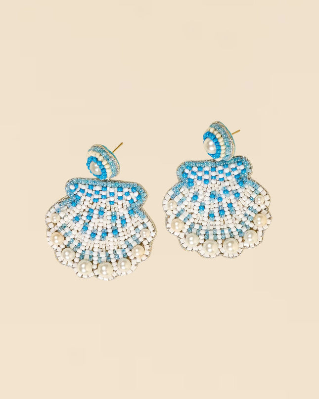 Pair of blue and white beaded earrings on a beige background