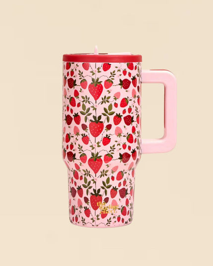Pink travel mug with strawberry pattern on a beige background