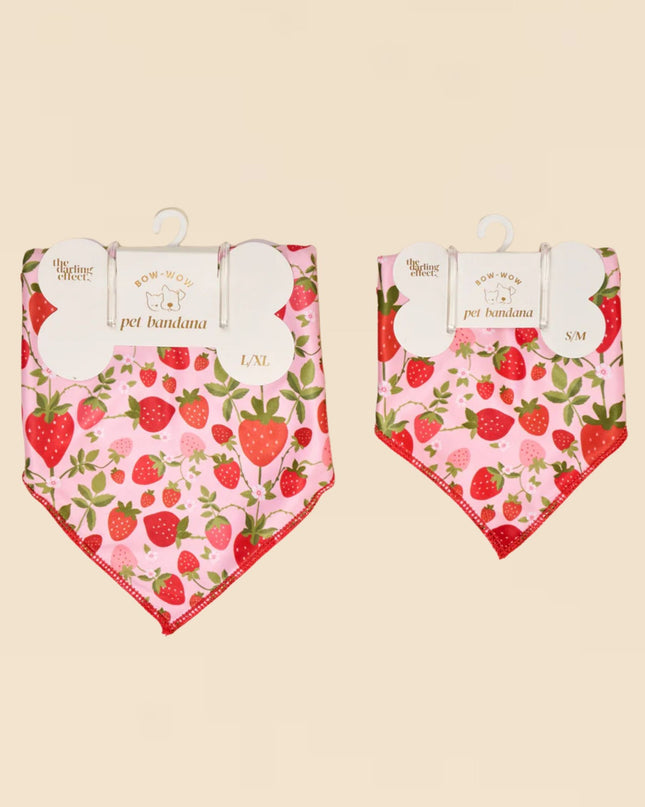 Two strawberry-patterned pet bandanas on a beige background