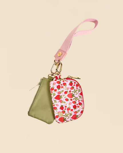 Two small pouches, one green and one with a strawberry pattern, on a beige background.