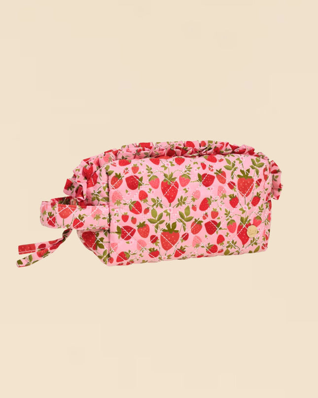 Pink fabric bag with strawberry pattern on a beige background