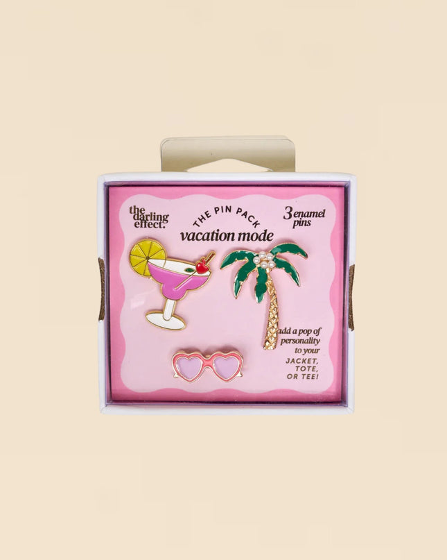 Pack of enamel pins with a palm tree, cocktail, and heart design on a pink background.