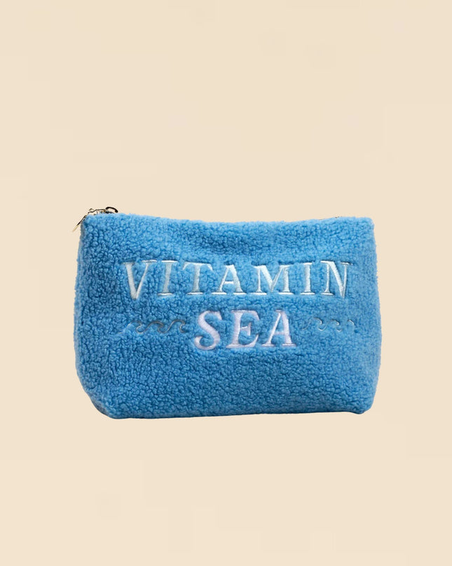 Blue pouch with 'Vitamin Sea' text on a beige background