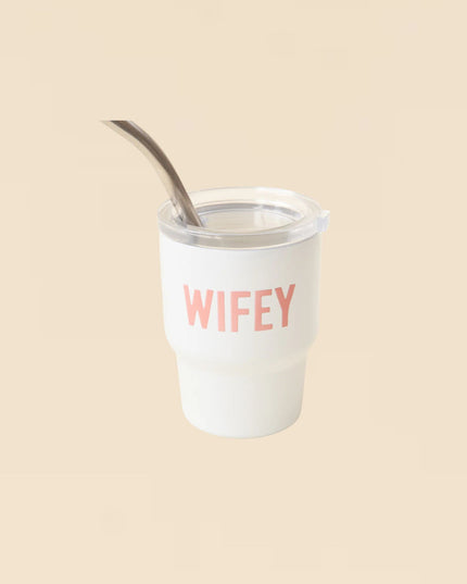 Clear tumbler with 'WIFEY' text and a metal straw on a beige background