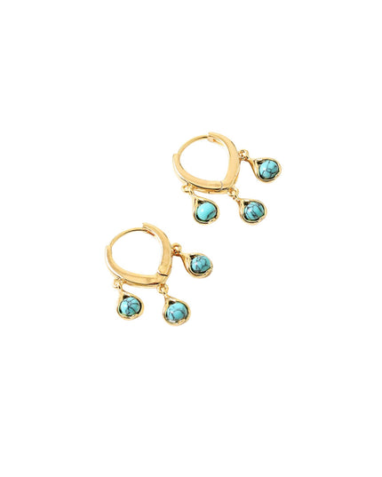 A pair of gold huggie hoop earrings with three dangling turquoise-colored stones on each earring, set against a plain white background.