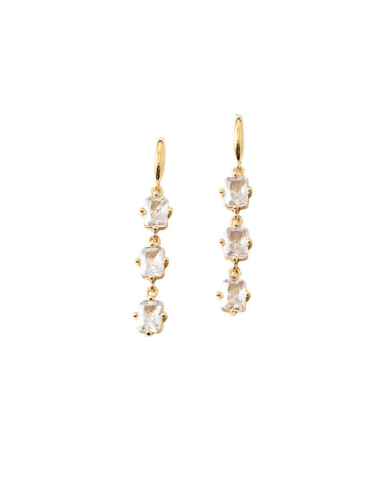 A pair of gold drop earrings featuring a vertical chain of four clear rectangular-cut gemstones in gold prong settings, shown against a plain white background.