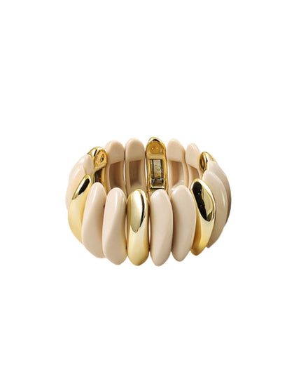 A wide, chunky cuff bracelet featuring alternating smooth, rounded segments in cream and polished gold-tone metal, shown on a plain white background.