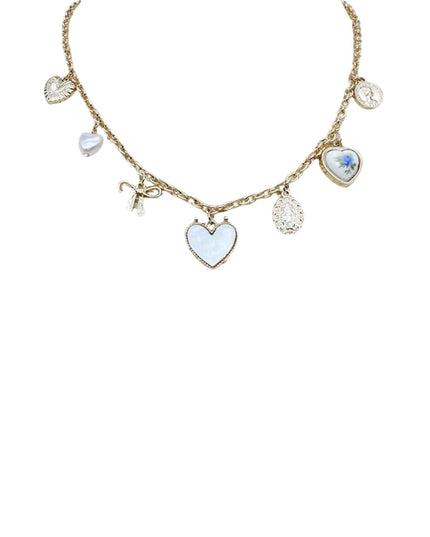 A gold-tone charm necklace featuring multiple heart-shaped charms, including a central light blue enamel heart, a smaller matching heart with a blue floral detail, and textured silver-toned heart charms on a white background.