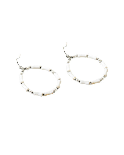 A pair of silver-tone hoop earrings with white cylindrical beads and small metallic spacer beads, shown on a plain white background.