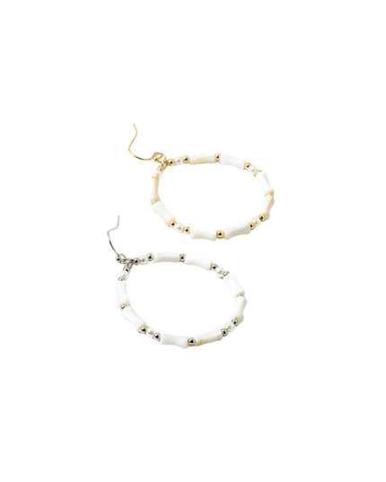 Two beaded hoop earrings on a plain white background, one with gold-tone hooks and white beads with small gold accents, and the other with silver-tone hooks and white beads with small silver accents.