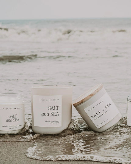 Candles and diffuser labeled 'Salt and Sea' on a beach setting